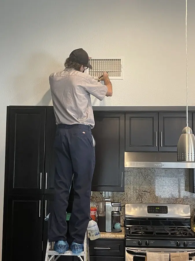 Technician inspecting an air vent during HVAC service in Carpentersville